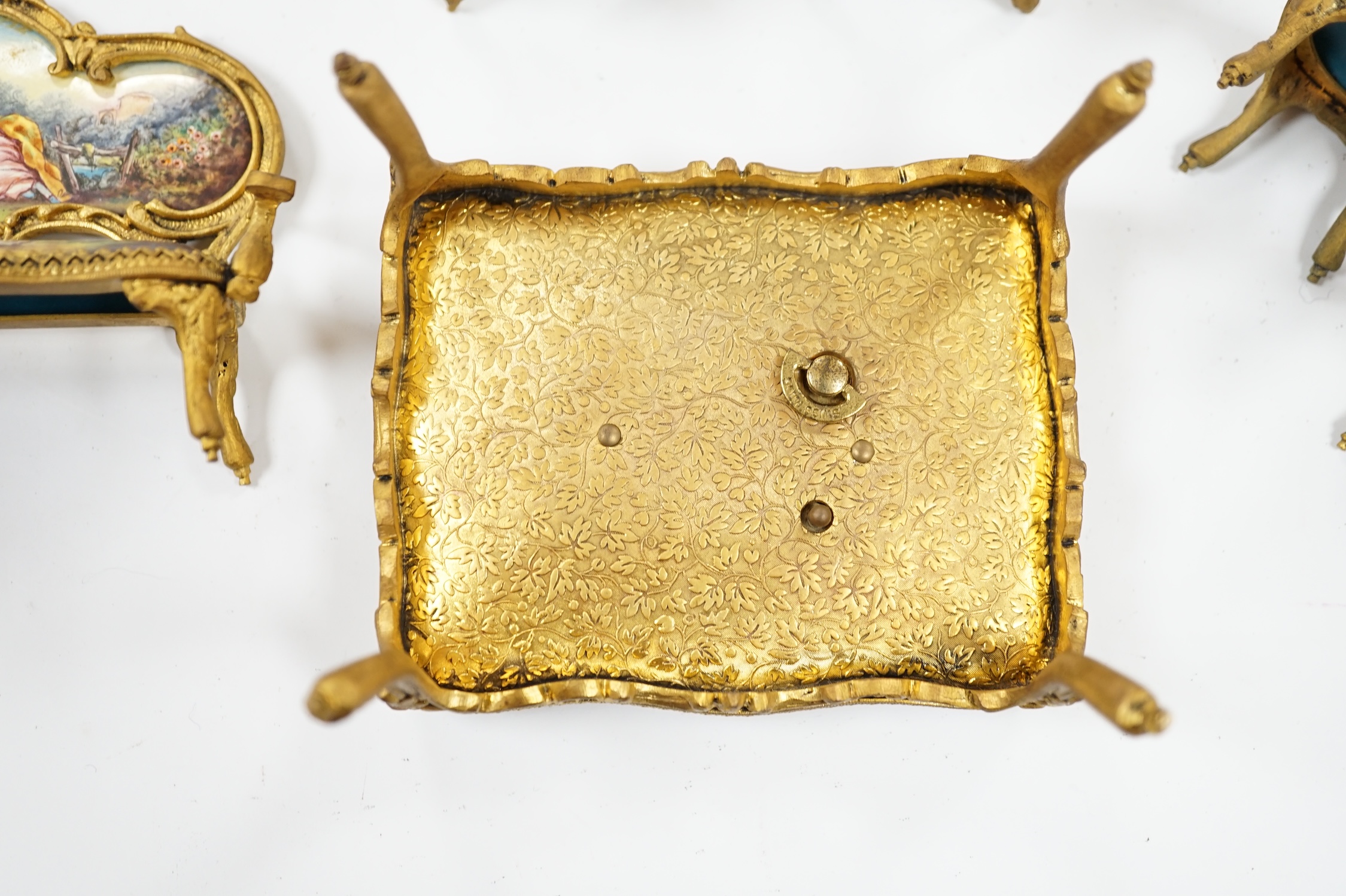 An early 20th century miniature enamel and gilt metal framed furniture set, possibly Austrian, largest 9cm wide. Condition - fair